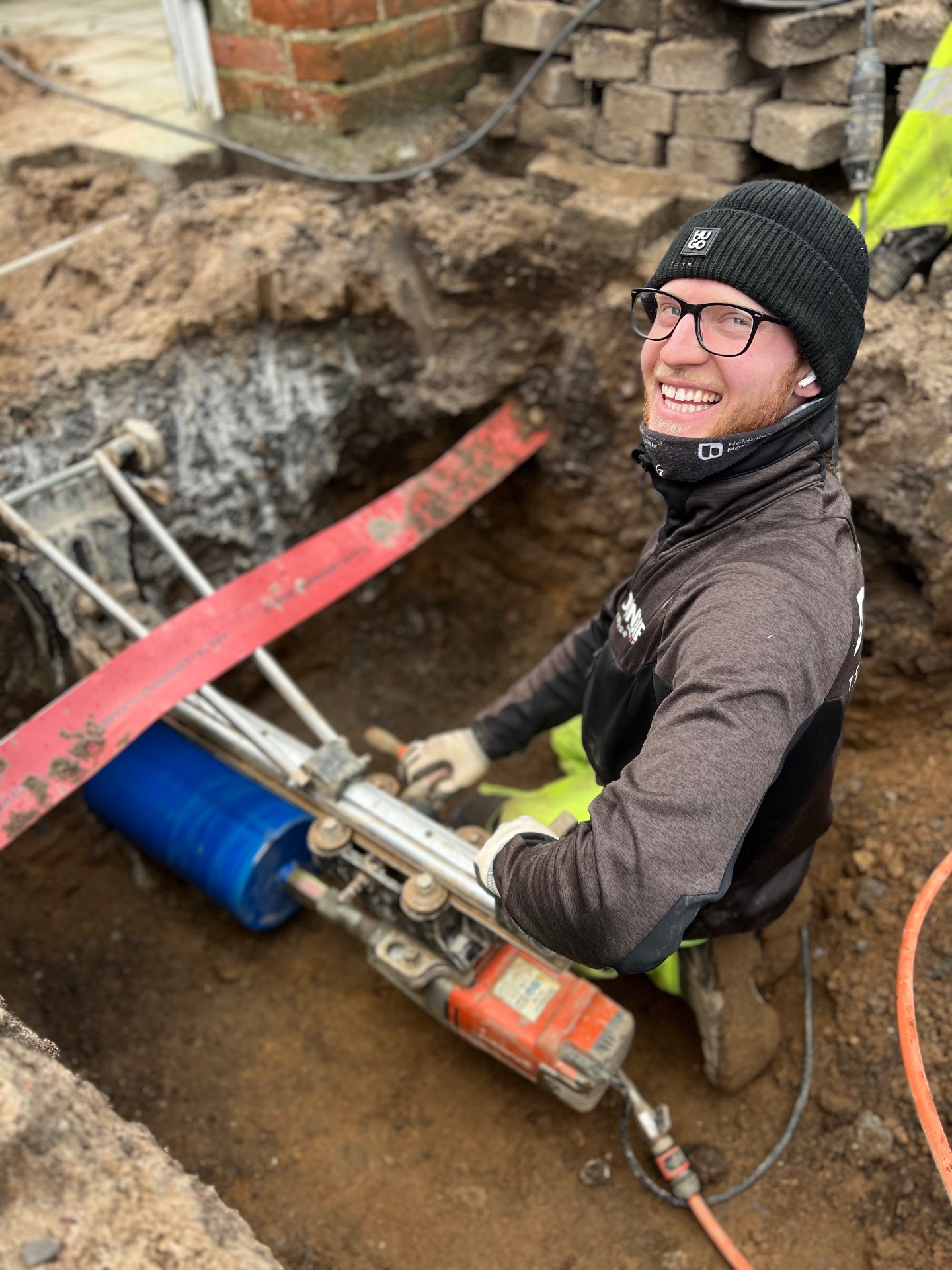 DONDIE worker operating trenching equipment at a residential job site
