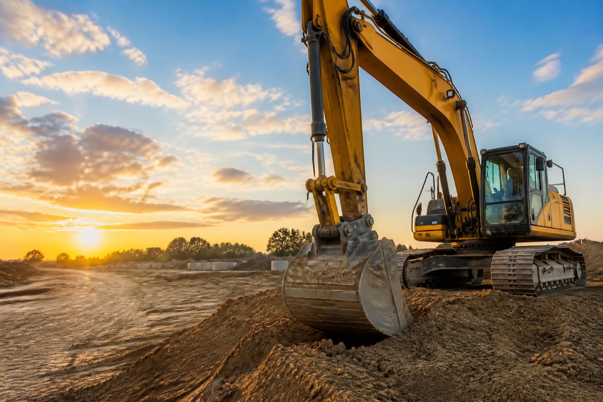 Excavator at a clean, organized construction site at golden hour